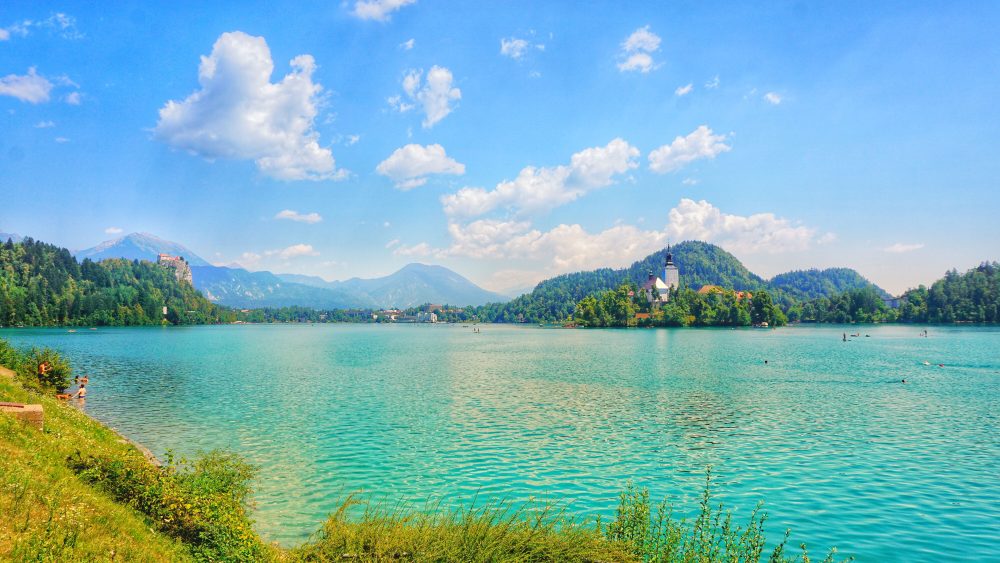 Blejsko jezero z otoško cerkvijo in okoliškimi gorami pod jasnim nebom